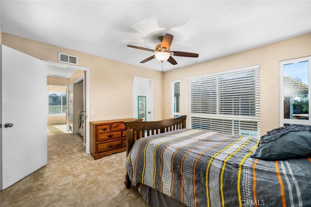 carpeted bedroom with ceiling fan and multiple windows