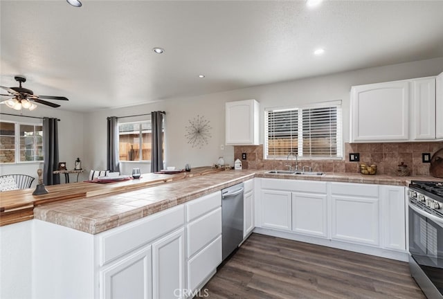 kitchen with kitchen peninsula, sink, and white cabinetry