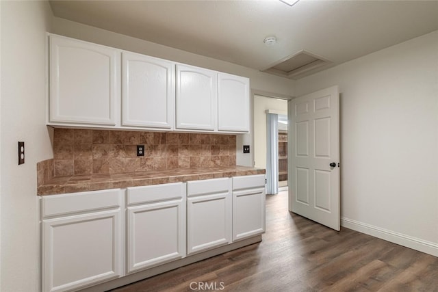 kitchen with tasteful backsplash, white cabinets, and dark hardwood / wood-style floors