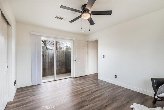 unfurnished office with ceiling fan and dark wood-type flooring