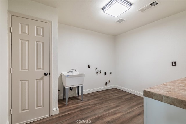 washroom with dark hardwood / wood-style floors and hookup for an electric dryer