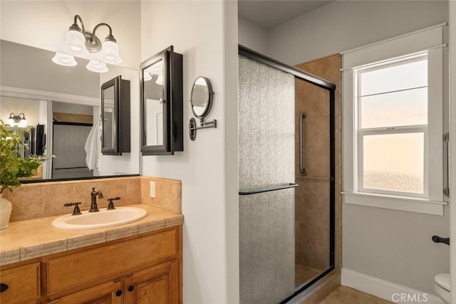 bathroom featuring toilet, walk in shower, and vanity