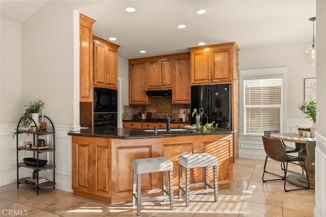 kitchen featuring light tile patterned floors, kitchen peninsula, decorative backsplash, pendant lighting, and black appliances