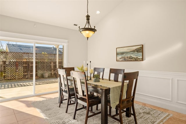 dining area with light tile patterned floors and vaulted ceiling