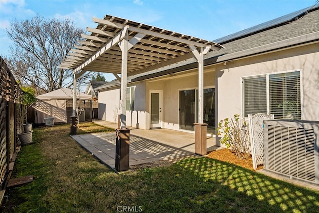 back of house featuring central air condition unit, a pergola, a lawn, and a patio