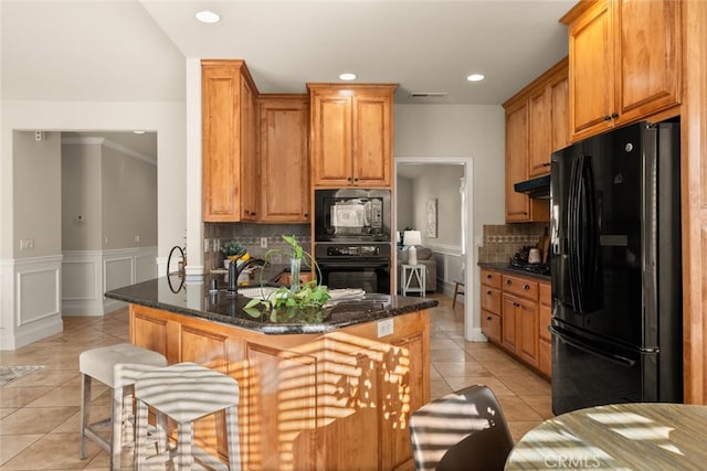 kitchen featuring black appliances, dark stone counters, tasteful backsplash, kitchen peninsula, and light tile patterned flooring