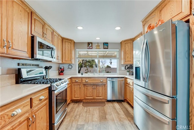 kitchen featuring sink, appliances with stainless steel finishes, and light hardwood / wood-style flooring