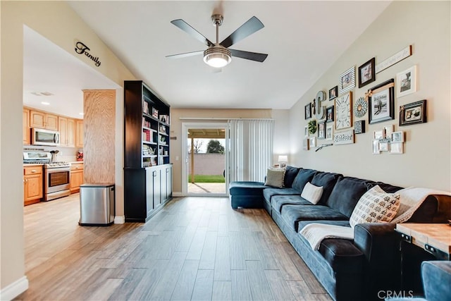 living room with light wood-type flooring and ceiling fan