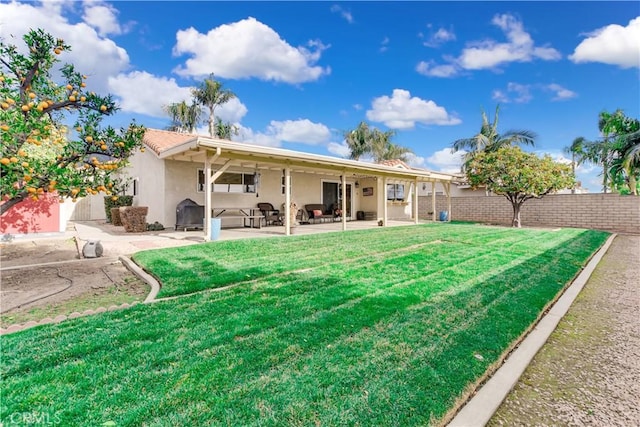 rear view of property with a lawn and a patio area