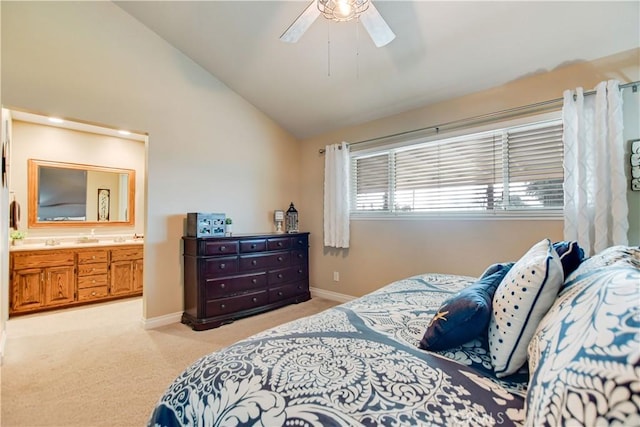 bedroom with ceiling fan, light colored carpet, connected bathroom, and vaulted ceiling