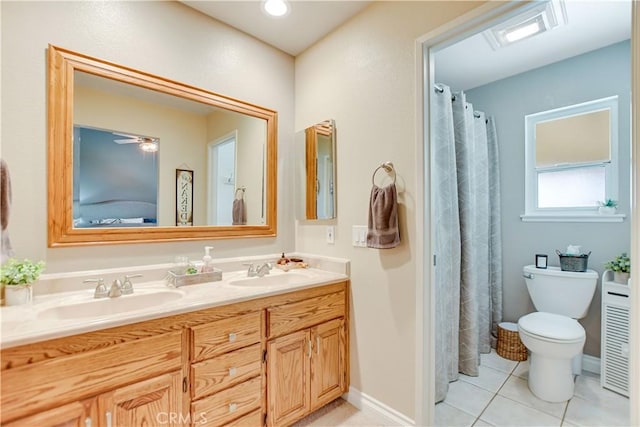 bathroom with toilet, vanity, and tile patterned floors