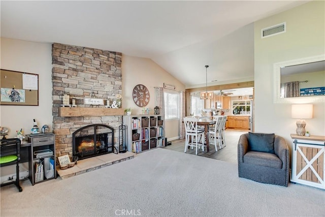 carpeted living room featuring ceiling fan, lofted ceiling, and a stone fireplace