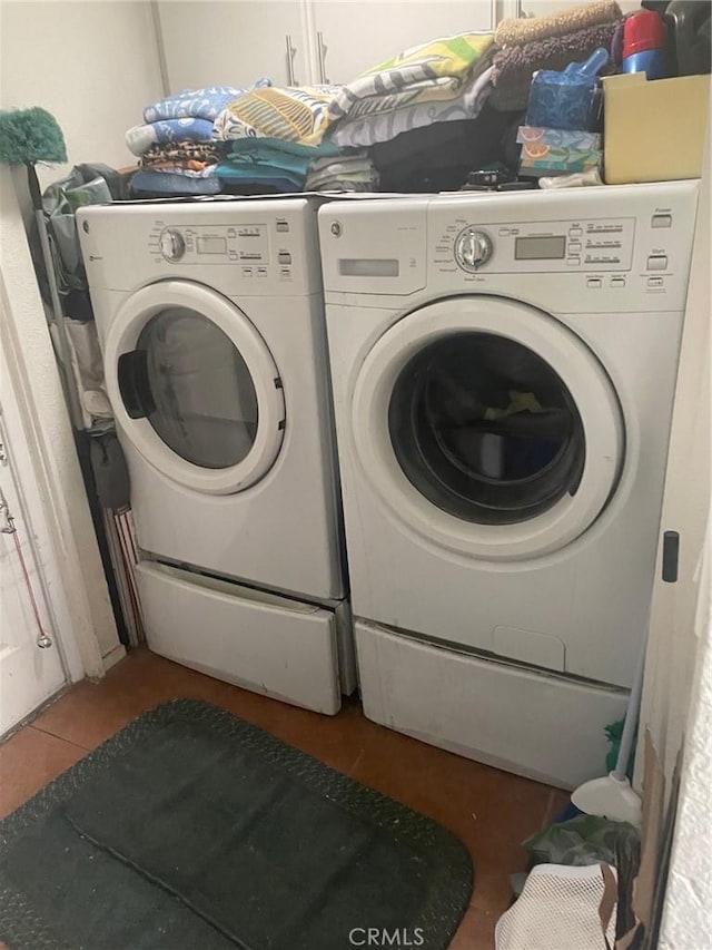 laundry area with washer and clothes dryer and tile patterned flooring