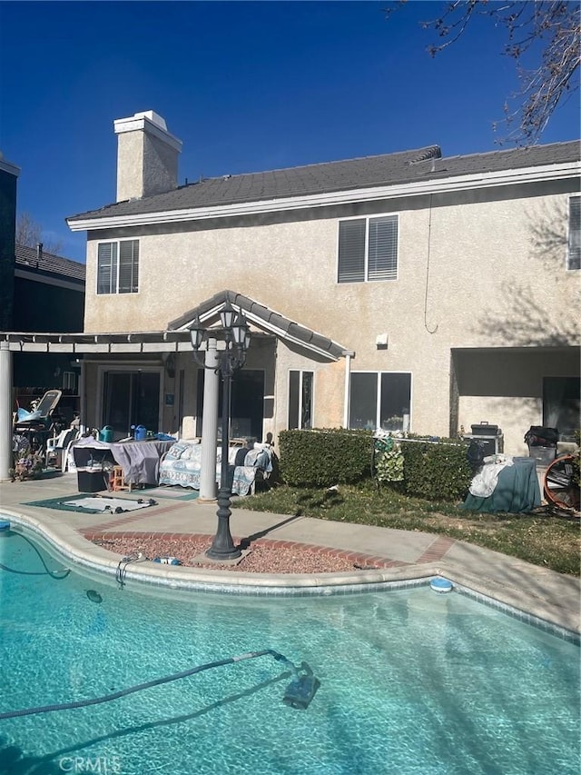 back of house with a pergola and a patio