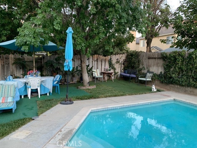 view of pool featuring a lawn