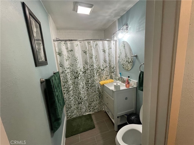 bathroom with toilet, vanity, and walk in shower