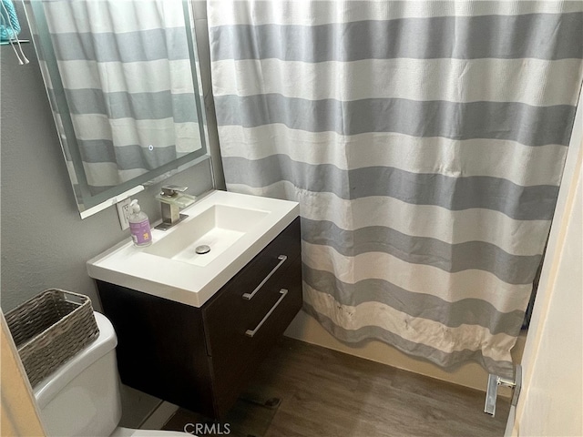 bathroom featuring wood-type flooring, toilet, and vanity