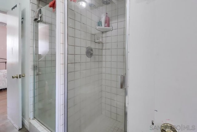 bathroom featuring a shower with door