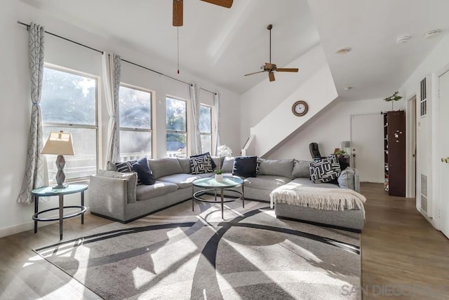 living room featuring ceiling fan, lofted ceiling, and light hardwood / wood-style flooring