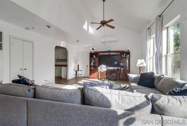 living room featuring ceiling fan, vaulted ceiling, and a wall mounted air conditioner