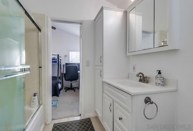 bathroom with shower / bath combination with glass door, vanity, and vaulted ceiling