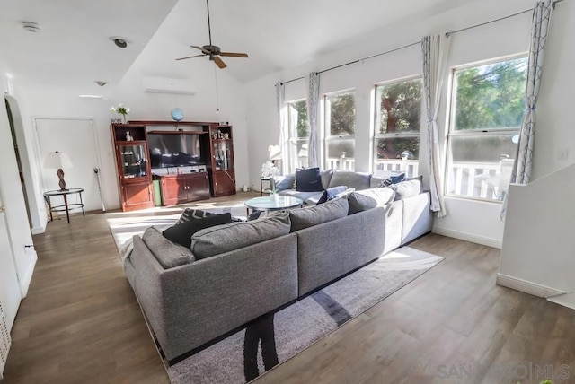 living room with hardwood / wood-style flooring, lofted ceiling, a wall unit AC, and ceiling fan