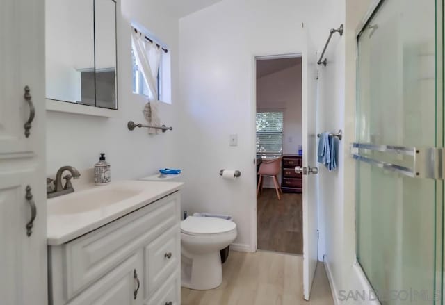 bathroom with hardwood / wood-style floors, walk in shower, vanity, and a healthy amount of sunlight