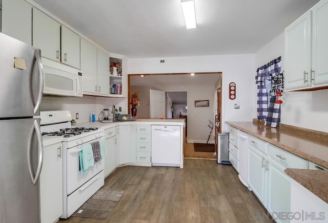 kitchen featuring light hardwood / wood-style floors, kitchen peninsula, decorative backsplash, white appliances, and white cabinetry