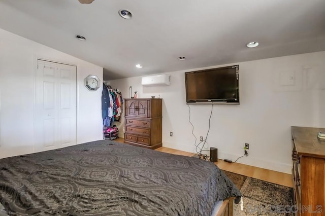 bedroom with a closet, a wall mounted AC, and vaulted ceiling