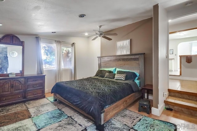 bedroom featuring ceiling fan, connected bathroom, and lofted ceiling