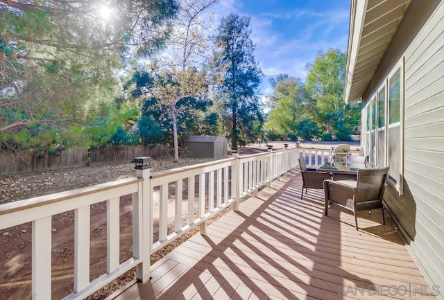 wooden terrace featuring a storage shed