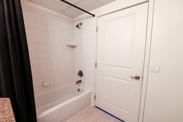 bathroom with tiled shower / bath combo, tile patterned floors, and a drop ceiling