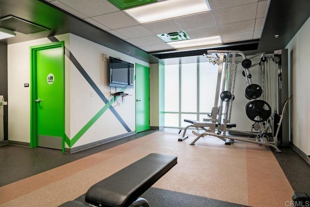 workout room with a paneled ceiling and expansive windows