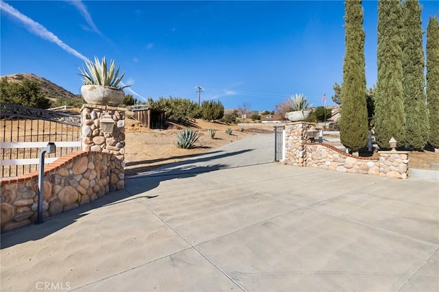 view of street featuring a gated entry and driveway