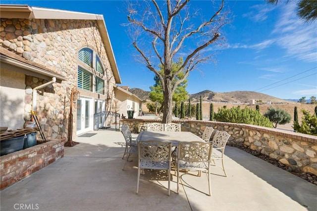 view of patio featuring a mountain view, french doors, and outdoor dining space