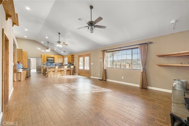 unfurnished living room featuring light wood finished floors, ceiling fan, baseboards, vaulted ceiling, and recessed lighting