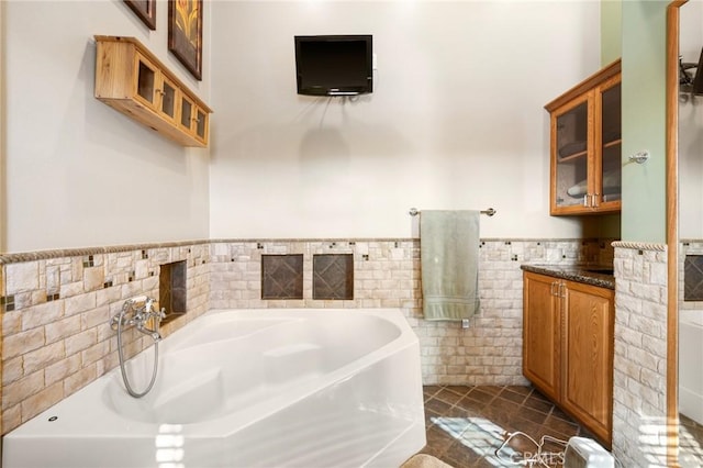 bathroom featuring tile patterned floors, wainscoting, tile walls, and a garden tub