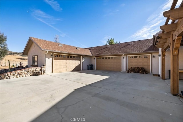 ranch-style home featuring stucco siding, concrete driveway, and an attached garage