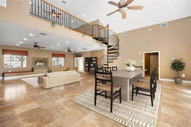 dining space featuring a wealth of natural light, visible vents, baseboards, and stairway