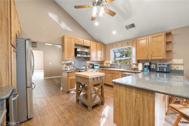 kitchen with visible vents, open shelves, a sink, appliances with stainless steel finishes, and a peninsula