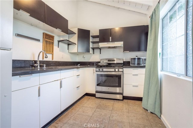 kitchen featuring white cabinets, appliances with stainless steel finishes, lofted ceiling, sink, and light tile patterned flooring