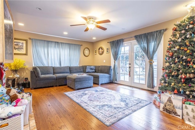 living room featuring light hardwood / wood-style floors, french doors, and ceiling fan