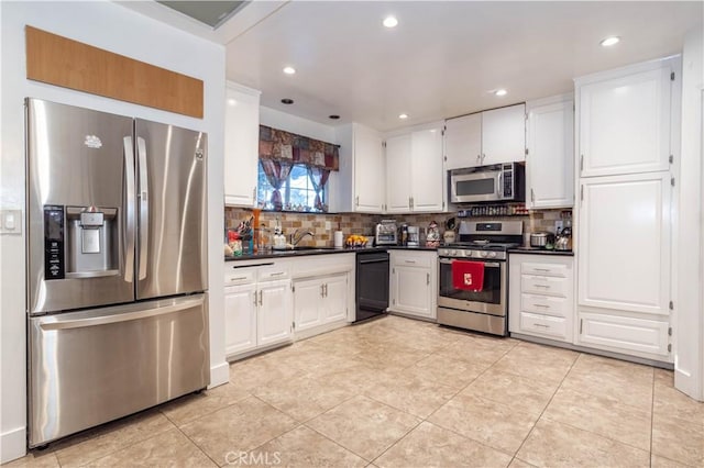 kitchen featuring light tile patterned floors, white cabinetry, appliances with stainless steel finishes, decorative backsplash, and sink