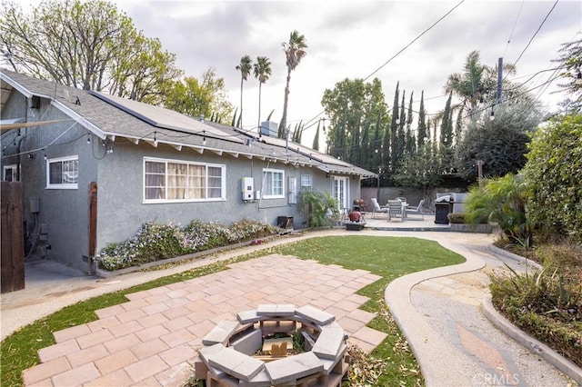 rear view of property featuring an outdoor fire pit and a patio