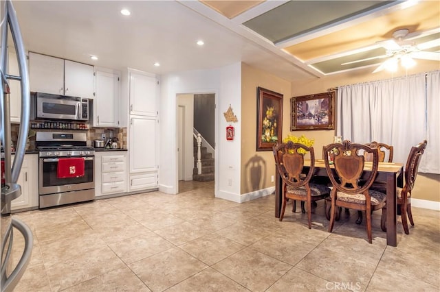 kitchen with tasteful backsplash, white cabinets, ceiling fan, and appliances with stainless steel finishes