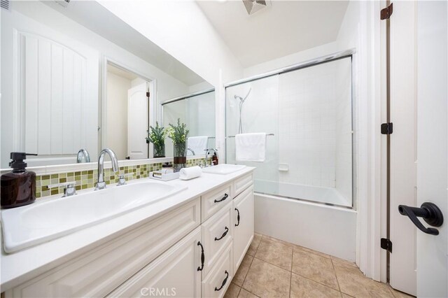 bathroom featuring tasteful backsplash, enclosed tub / shower combo, vanity, and tile patterned floors