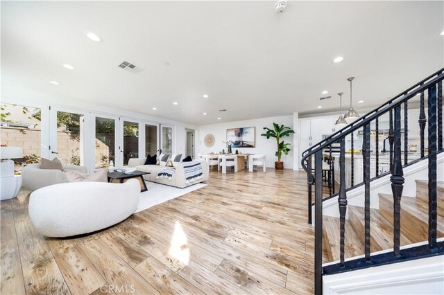 living room featuring french doors and light wood-type flooring