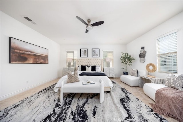 bedroom featuring ceiling fan, light colored carpet, and multiple windows