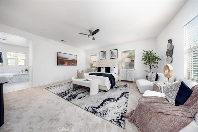 carpeted bedroom featuring ceiling fan and ensuite bath