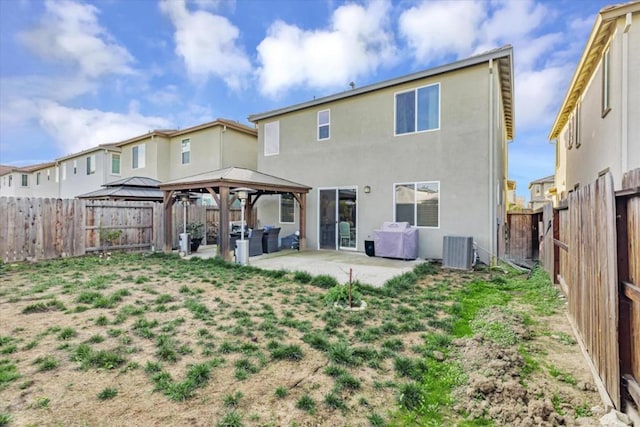 rear view of property with a gazebo, a patio area, a yard, and cooling unit